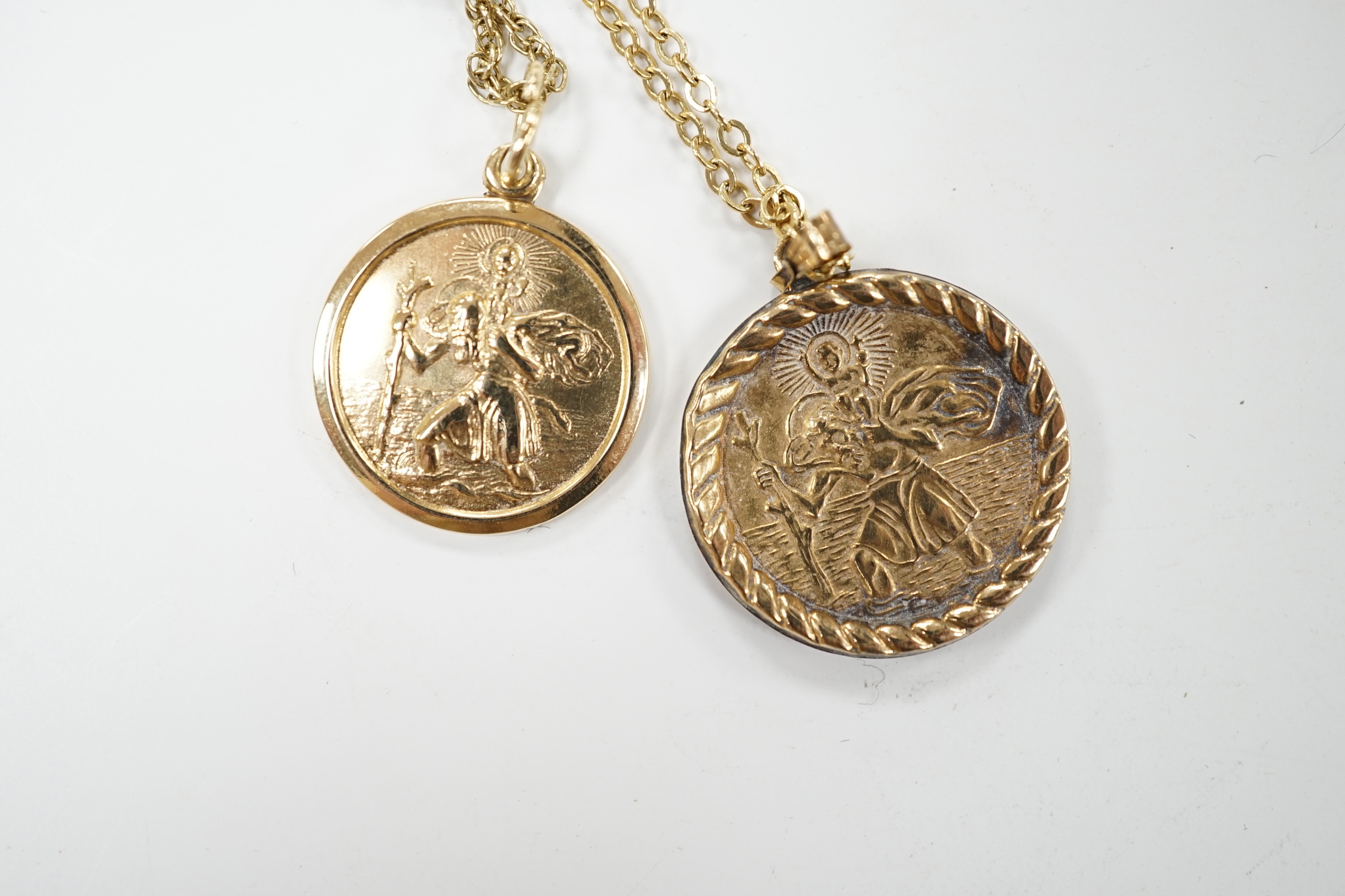 Two yellow metal St Christopher pendants, on 9k chains. Condition - poor to fair